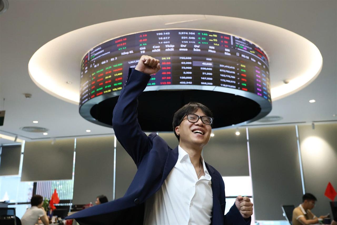 An excited AAS specialist beneath the electronic stock board on the trading floor